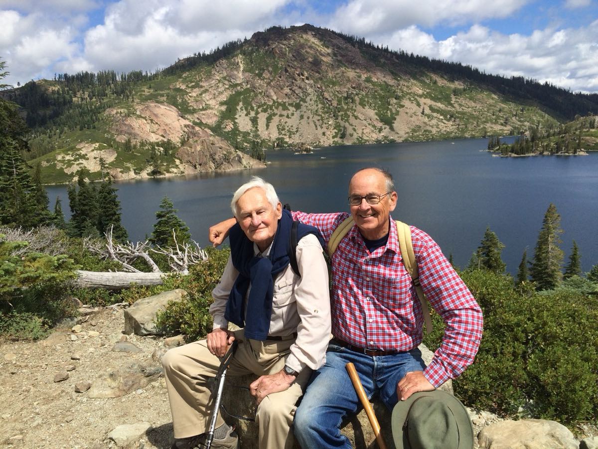 Alexander Kugushev hiking with Bill Wood at a mountain lake