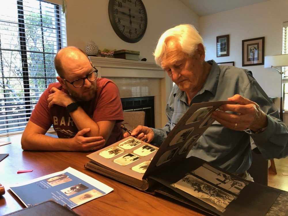 Alexander Kugushev looking through a family photo album with a guest